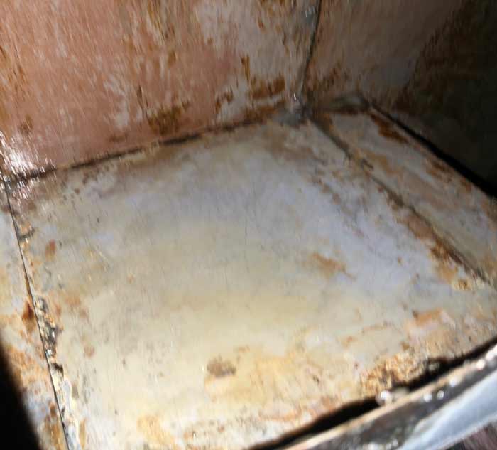 Interior of commercial exhaust ductwork scraped to bare metal standard to meet NFPA 96 fire safety compliance.