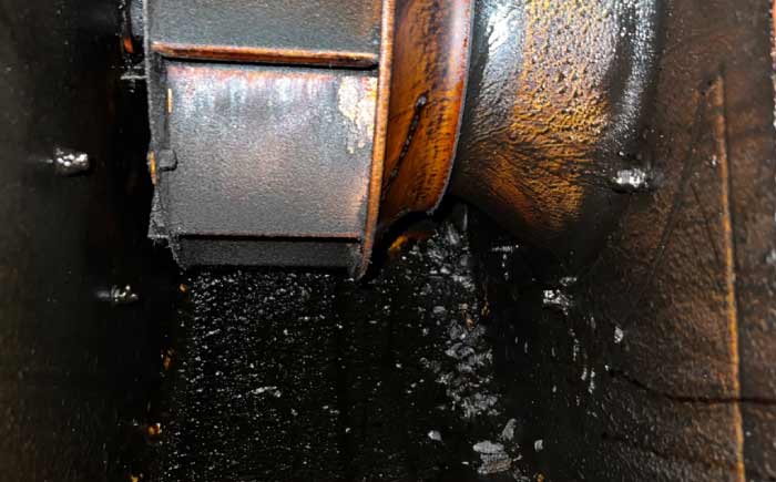 Rooftop exhaust fan impeller heavily caked in black grease sludge requiring immediate commercial cleaning kitchen service.
