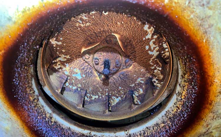 Heavy grease accumulation on a commercial kitchen exhaust fan blade presenting a severe fire hazard before cleaning.